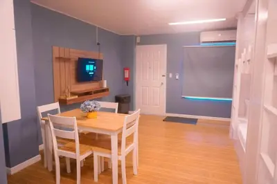 a dining room with a table and chairs and a screen at ALTEAN Apartments - Lydia Room in Manila