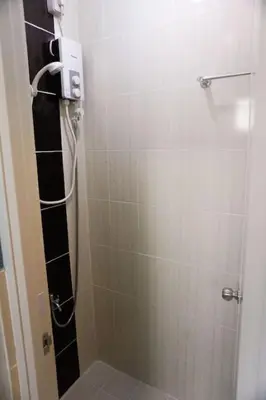 a bathroom with a shower with a glass door at ALTEAN Apartments - Lydia Room in Manila