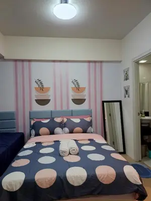 a bedroom with a bed with two stuffed animals on it at Avah de lara condotel NAIA T3 in Manila