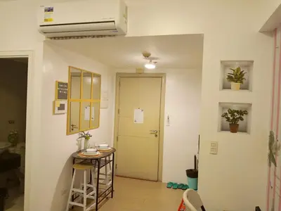 a room with a hallway with a door and a table at Avah de lara condotel NAIA T3 in Manila