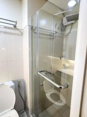 a bathroom with a glass shower with a toilet at Pasay City MOA, Pearl Suite in Shell Residences in Manila