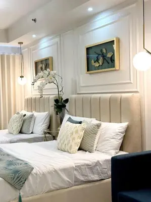 a living room with two beds with pillows at Pasay City MOA, Pearl Suite in Shell Residences in Manila