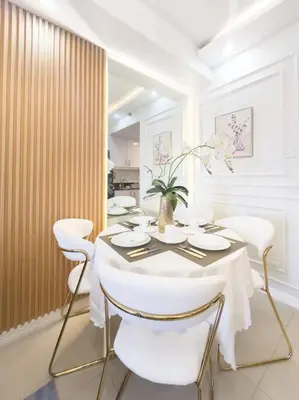 a dining room with a table and white chairs at Pasay City MOA, Pearl Suite in Shell Residences in Manila