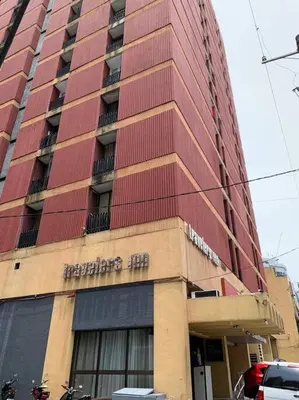 a tall building with a sign on the side of it at Travelers Inn - Cozy Capsule Bunks, Makati in Manila