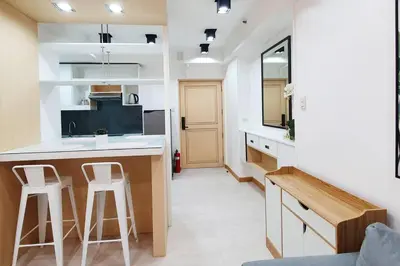 a kitchen with a counter and two bar stools at Travelers Inn - Cozy Capsule Bunks, Makati in Manila