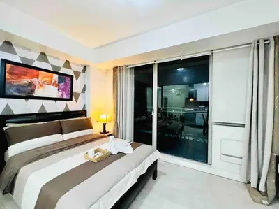 a bedroom with a large bed and a large window at Azure cozy corners in Manila