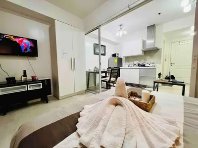 a living room with a couch and a kitchen at Azure cozy corners in Manila