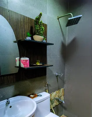 a bathroom with a toilet and a sink and a mirror at House of Citiflora Unit B in Manila