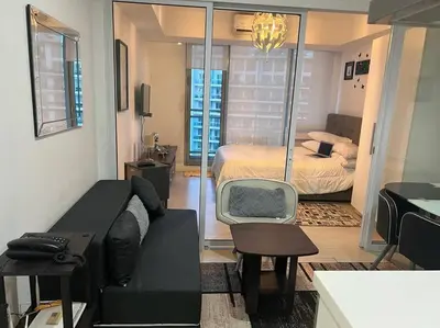 a living room with a couch and a bedroom at Azure Urban Resort a12 Wavepool near mall airport in Manila