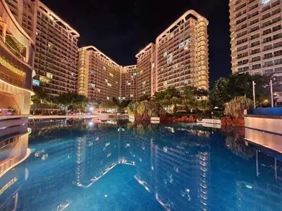 a large swimming pool in front of buildings at night at Azure Urban Resort a12 Wavepool near mall airport in Manila