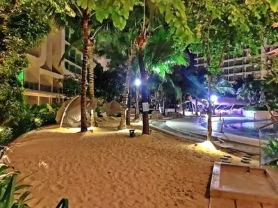 a park with palm trees and a pool at night at Azure Urban Resort a13 near airport wavepool in Manila