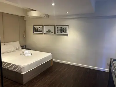 a bedroom with a bed and three pictures on the wall at Melbourne makati in Manila
