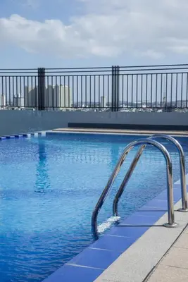 a swimming pool with a metal hand rail on a building at Melbourne makati in Manila
