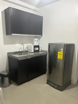 a kitchen with a sink and a refrigerator at Melbourne makati in Manila