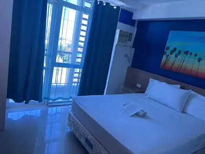 a bedroom with a large white bed with blue walls at Melbourne makati in Manila