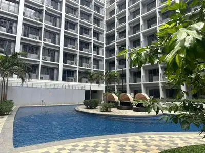 a large building with a swimming pool in front of it at Shabby Chic & Contemporary Condo in Manila