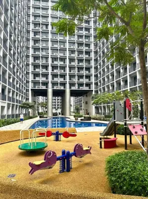 a playground in front of a large building at Shabby Chic & Contemporary Condo in Manila