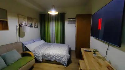 a living room with a bed and a television at J Studio - Fast WiFi, 55