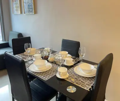 a dining room table with glasses and plates on it at 8 Adriatico - 1 Bedroom with 1 Parking Space near SLMEC, PGH and US Embassy in Manila