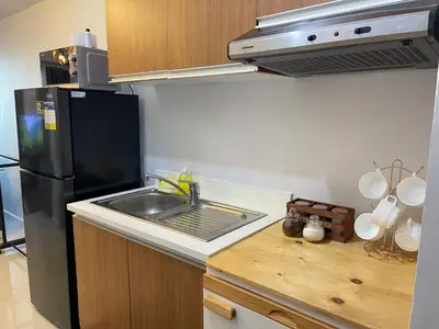a kitchen with a sink and a stainless steel refrigerator at 8 Adriatico - 1 Bedroom with 1 Parking Space near SLMEC, PGH and US Embassy in Manila