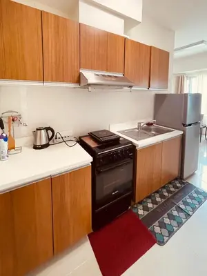 a small kitchen with a stove and a sink at 8 Adriatico - 1 Bedroom with 1 Parking Space near SLMEC, PGH and US Embassy in Manila