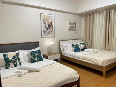 a bedroom with two beds and a window at 8 Adriatico - 1 Bedroom with 1 Parking Space near SLMEC, PGH and US Embassy in Manila