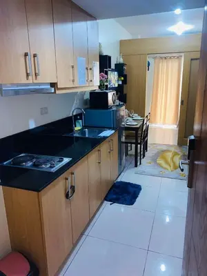 a kitchen with a sink and a counter top at Triple 3D Shell Residences in Manila