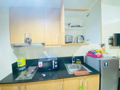 a kitchen counter with a sink and a microwave at Triple 3D Shell Residences in Manila