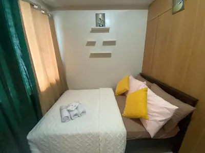 a small bedroom with a bed with towels on it at Triple 3D Shell Residences in Manila