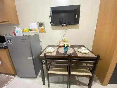 a small kitchen with a table and a refrigerator at Triple 3D Shell Residences in Manila