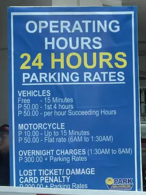 a sign for a hours parking rates at Triple 3D Shell Residences in Manila