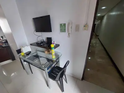 a glass table with a chair and a television in a room at Experience OCEAN VIEW Rooms in The Heart Of Manila, Enjoy FREE ACCESS To The POOL, SAUNA, PLUS MASSAGE PROMO In Prime Location Near The US Embassy, NAIA, Makati, BGC, Mall of Asia, And Chinatown This Is A Limited-Time Offer, Book Now in Manila