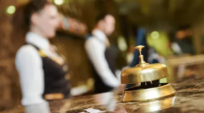 a bell sitting on top of a counter with two men at Experience OCEAN VIEW Rooms in The Heart Of Manila, Enjoy FREE ACCESS To The POOL, SAUNA, PLUS MASSAGE PROMO In Prime Location Near The US Embassy, NAIA, Makati, BGC, Mall of Asia, And Chinatown This Is A Limited-Time Offer, Book Now in Manila