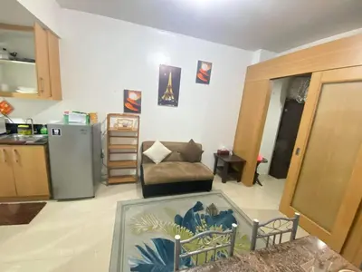 a living room with a couch and a refrigerator at YUYANS Staycation Shell Residences in Manila