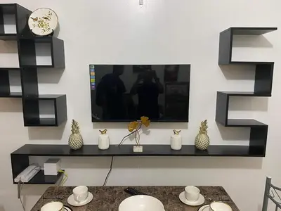 a living room with a tv on a wall at YUYANS Staycation Shell Residences in Manila