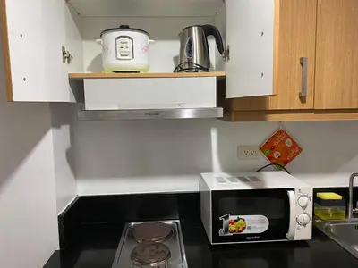 a kitchen with a microwave oven and a sink at YUYANS Staycation Shell Residences in Manila