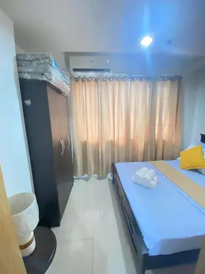 a small bedroom with a blue bed and a window at YUYANS Staycation Shell Residences in Manila