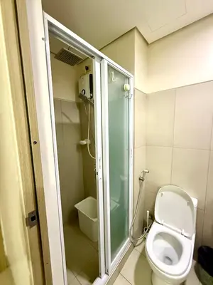 a bathroom with a toilet and a glass shower at 2 BR Condo SMDC Breeze Residences in Manila