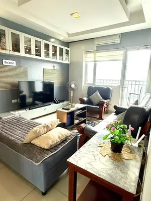 a living room with a couch and a tv at 2 BR Condo SMDC Breeze Residences in Manila