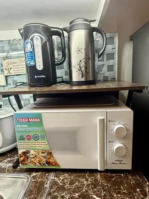a microwave and a coffee pot and a box of pizza at 2 BR Condo SMDC Breeze Residences in Manila