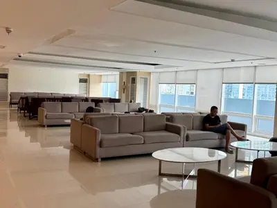 a man sitting on a couch in a lobby at 2 BR Condo SMDC Breeze Residences in Manila