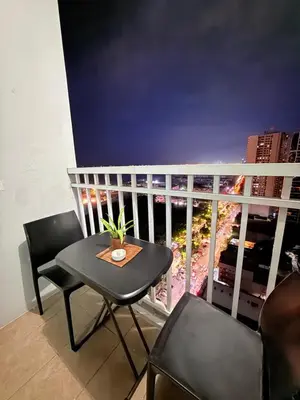 a balcony with a table and chairs and a view at 2 BR Condo SMDC Breeze Residences in Manila