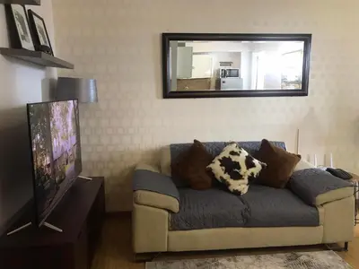 a living room with a couch and a mirror at Simple Yet Lovely 2BR Unit in Acqua Private Residences in Manila