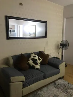 a couch in a living room with a mirror at Simple Yet Lovely 2BR Unit in Acqua Private Residences in Manila
