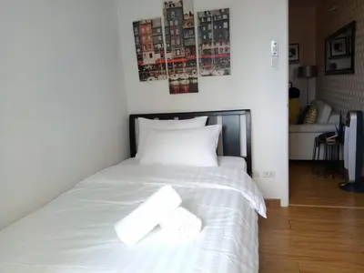 a white bed with two white towels on it at Simple Yet Lovely 2BR Unit in Acqua Private Residences in Manila