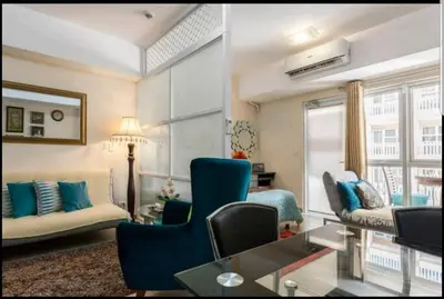 a living room with blue chairs and a couch at Venice Luxury Residences, Tower B, McKinley Hill, Taguig in Manila
