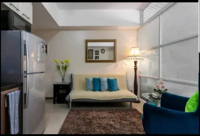 a living room with a couch and blue pillows at Venice Luxury Residences, Tower B, McKinley Hill, Taguig in Manila