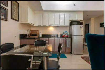 a kitchen with a table and chairs and a refrigerator at Venice Luxury Residences, Tower B, McKinley Hill, Taguig in Manila