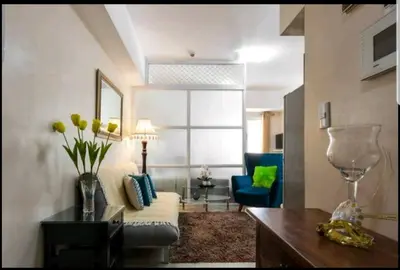 a living room with a couch and a blue chair at Venice Luxury Residences, Tower B, McKinley Hill, Taguig in Manila
