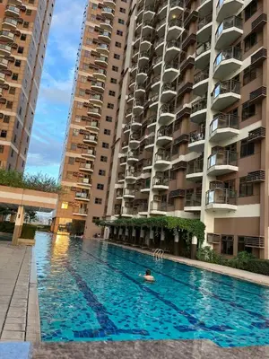 a person swimming in a swimming pool in front of buildings at Bayview near PICC CCP starcity OKADA Airport MOA in Manila